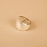 Anillo de plata 925 con diseño de banda ancha en la parte superior y más estrecha en la inferior, acabado pulido.