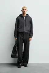 Sudadera de corte relajado confeccionada en tejido compacto de algodón con interior forrado, cuello con capucha, manga larga, bolsillos frontales tipo canguro y acabados en rib.