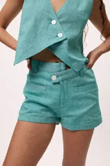 Short de corte sastrero color turquesa, con cierre frontal de botón y bolsillos laterales.