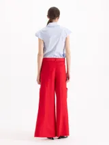 Pantalon wide leg blanco de lino, con tiro alto y bolsillos cargo laterales. Incluye cinturón con hebilla metálica.