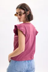 Camiseta sin mangas color bordó con detalle de volados en los hombros y cuello redondo.