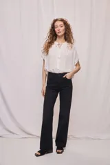 Pantalón jean wide leg de tiro alto y calce relajado, color negro, con diseño clásico de cinco bolsillos y cierre frontal con botón y cremallera.