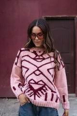 Sweater de punto oversize con diseño jacquard geométrico en tonos gris y crema. Presenta cuello redondo a la base, mangas largas y terminaciones en punto elástico acanalado.