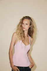 Top negro con cuello halter y escote en pico. Se ata con lazo en la espalda y tiene cierre lateral con cremallera oculta.