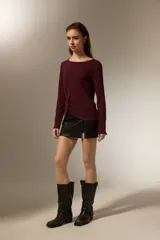 Remera de manga larga color bordó, confeccionada en viscosa, con cuello redondo y detalle de nudo lateral que genera un drapeado suave.