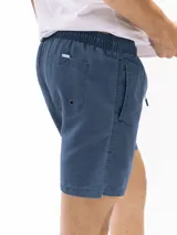 Short de baño de microfibra negro, con cordón blanco ajustable en la cintura, bolsillos laterales y un bolsillo trasero con tapa. Presenta un pequeño parche cuadrado con un logo en la parte inferior del muslo izquierdo.