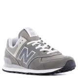 Championes urbanos New Balance modelo 574, color gris con detalles en blanco y negro. Confeccionados en una combinación de gamuza y tejido técnico, presentan el logo N característico en los laterales, entresuela ENCAP para mayor soporte y suela de goma con diseño inspirado en trail.