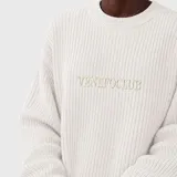 Sweater de punto acanalado en color blanco, con cuello redondo y diseño de mangas largas. Presenta el logo de la marca bordado en el centro del pecho.