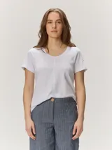 Remera básica blanca de manga corta, con cuello redondo y costuras verticales decorativas en el frente.