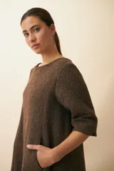 Vestido midi acampanado de lana fina sin teñir, con cuello bote, mangas tres cuartos con tajo y bolsillos laterales. Diseño forrado con vuelo y movimiento.