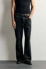 Jeans flare fit de denim negro, tiro medio, ajustados arriba y con botamanga acampanada. Cuentan con cinco bolsillos, lavado efecto gastado y bajo con acabado irregular. Cierre frontal con cremallera y botón.