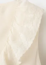 Vestido midi recto color beige sin mangas, con cuello en V con solapa de volantes bordados y cordones entrecruzados en el escote.