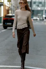 Camiseta de manga larga color beige, con cuello redondo y detalle de camiseta interior en el mismo tejido. Tiene un bajo asimétrico y corte slim fit.