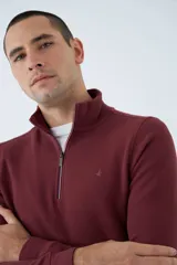 Buzo de hombre color bordó, con medio cierre frontal, cuello alto y logo estampado en el pecho. De corte regular y manga larga.