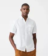 Camisa de hombre de manga corta confeccionada en una mezcla de lino y algodón. Presenta un corte confort, cuello clásico, cierre frontal con botones y un bolsillo de parche en el pecho. Las mangas cortas cuentan con un detalle de dobladillo.