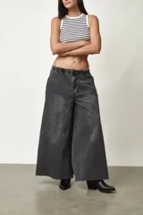 Jean de corte ancho y silueta oversize, color gris oscuro con efecto acid wash. Presenta pretina elástica y ruedo desmechado.