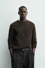 Jersey de punto regular fit, confeccionado en una mezcla de lana y fibra de alpaca. Presenta cuello redondo, manga larga y acabados en rib en puños y bajo.