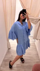 Vestido corto color verde militar, con cuello mao, botones frontales, mangas cortas acampanadas y volados en el ruedo. Confeccionado en lino. Fabricado en Italia.