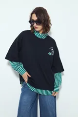 Remera negra de manga corta con calce relajado y cuello a la base. Presenta un pequeño estampado frontal de un perro con un plato y un estampado protagonista en la espalda con la palabra "AROMO" y un diseño gráfico.