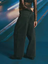 Jean de corte wide leg en color celeste claro con lavado desgastado. Presenta un diseño de cinco bolsillos, incluyendo bolsillos laterales tipo cargo, cierre frontal con botón y bragueta, y costuras reforzadas en las piernas.