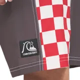 Boardshort Quiksilver de 16 pulgadas, color marrón con bandas laterales de diseño a cuadros rojos y blancos. Posee cintura fija con cordón de ajuste blanco y costuras visibles en contraste.