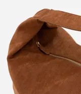 Bolso hobo de gamuza color marrón, con forma de media luna, cierre de cremallera y bretel ancho.