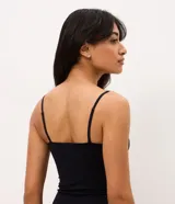 Camisete negro de microfibra con copa estructurada, escote recto y breteles finos regulables.