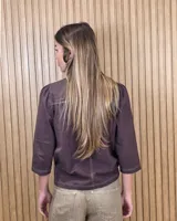 Camisa de algodón color blanco, con cuello alto con volados, mangas tres cuartos con detalles de bordado ingles y cierre frontal con botones de nácar.