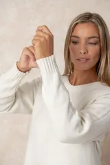 Buzo de corte relajado y cuello redondo, con detalles de costura vertical en la parte inferior y puños acanalados en las mangas.