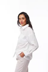 Camisa blanca de algodón con cuello clásico, manga larga y bolsillo en el pecho.