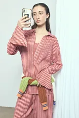 Camisa de viscosa con estampado de rayas verticales en tonos rosado y marrón, de corte oversize, con cuello camisero, cierre frontal de botones y mangas largas acampanadas.