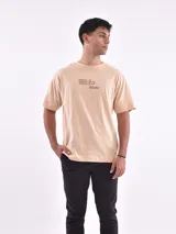 Remera blanca de corte holgado con la frase "The Good Old Days" estampada en color naranja.