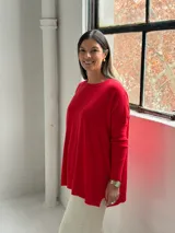 Sweater de punto color rojo, con cuello redondo, mangas largas con puños acanalados y diseño holgado con detalle de costura vertical central.