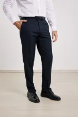 Pantalón de vestir azul marino, de corte recto, con bolsillos laterales y traseros. Se ajusta a la cintura con cinturón de cuero negro.
