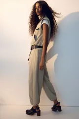 Camisa cargo sin mangas de nylon color beige, con cuello alto, cierre frontal de botones, bolsillos superiores con solapa y bolsillos delanteros diagonales. Cuenta con elástico oculto en el bajo.