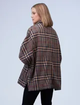 Poncho de tejido soft, marca Weatherproof, con diseño a cuadros en tonos azul marino, beige y celeste. Posee cuello alto con cierre metálico y bolsillos delanteros.