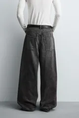 Jeans de denim de algodón, color azul oscuro con efecto lavado. Presentan un corte muy holgado (baggy fit) en toda la pierna y tiro medio. Tienen cinco bolsillos y cierre frontal con cremallera y botón.