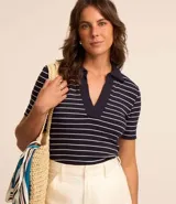 Blusa de ribana azul marino con rayas horizontales blancas, cuello polo en pico y mangas cortas.