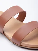Sandalia baja color marrón de símil cuero con doble tira sobre el empeine.