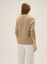 Cardigan de punto color blanco marfil, con escote en V, mangas largas con detalles de tejido calado y cierre frontal de botones con efecto madera.