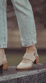 Zapato de taco ancho y medio, color negro, confeccionado en cuero. Presenta diseño destalonado con tira ajustable en el talón, faja ancha de gamuza sobre el empeine y puntera fina de charol.