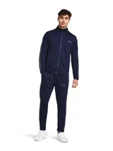 Conjunto deportivo de dos piezas compuesto por una chaqueta con cierre frontal y un pantalón de corte ajustado. Confeccionado en tejido de punto tricot con interior suave, diseñado para absorber el sudor y secarse rápidamente. La chaqueta cuenta con bolsillos laterales abiertos, mientras que el pantalón presenta cintura elástica con cordón ajustable y bolsillos laterales de malla.