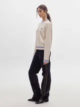 Pantalón de tiro medio confeccionado en pana negra, de corte holgado y diseño recto, con detalle de línea lateral en tono contrastante.