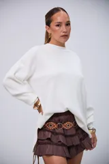 Sweater blanco de punto con cuello redondo, mangas largas y corte holgado con aberturas laterales.