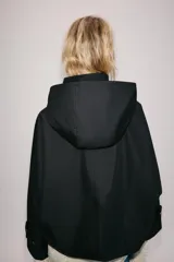 Cazadora negra ZW Collection de cuello subido con capucha, manga larga y bolsillos delanteros. Presenta forro interior a contraste y cierre frontal cruzado con botones a presión dorados.