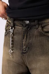 Bermuda de jean con corte baggy y lavado vintage en tono marrón oscuro. Presenta un diseño amplio y cómodo con bordes deshilachados en el ruedo, evocando un estilo nostálgico de los años 2000.