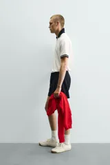 Polo de corte relajado confeccionado en piqué de algodón color blanco. Presenta cuello solapa en color negro con abertura frontal, mangas cortas con ribetes a contraste y estampado conmemorativo USA 94 FIFA World Cup.