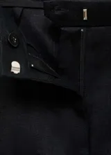 Pantalón de lino color negro, con diseño recto de tiro medio y cierre delantero con botón, gancho y cremallera ocultos. Cuenta con dos bolsillos laterales.