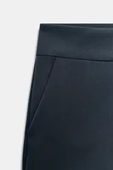Shorts de tiro medio en color crudo, con bolsillos laterales delanteros y cierre frontal con cremallera y ganchos metálicos.