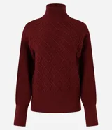 Suéter de manga larga confeccionado en tricot, con cuello alto y diseño de bordado de rombos en relieve. Presenta puños y ruedo acanalados.